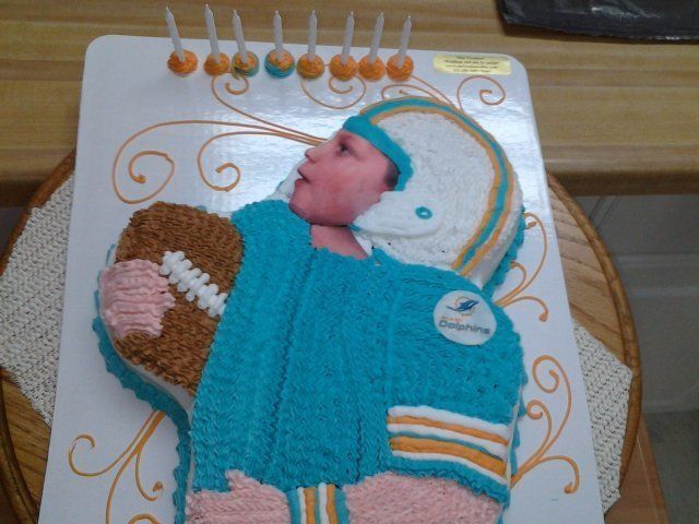 Cake shaped like a football player in a turquoise jersey, holding a football.