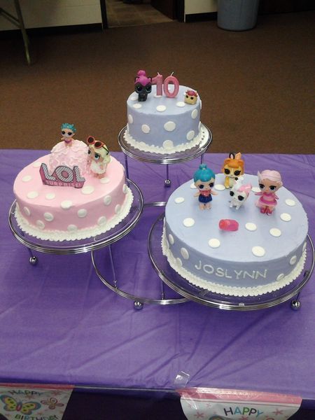 Three-tiered cake stand with polka-dotted cakes. Each cake has LOL Surprise dolls and a number 10 candle on top.