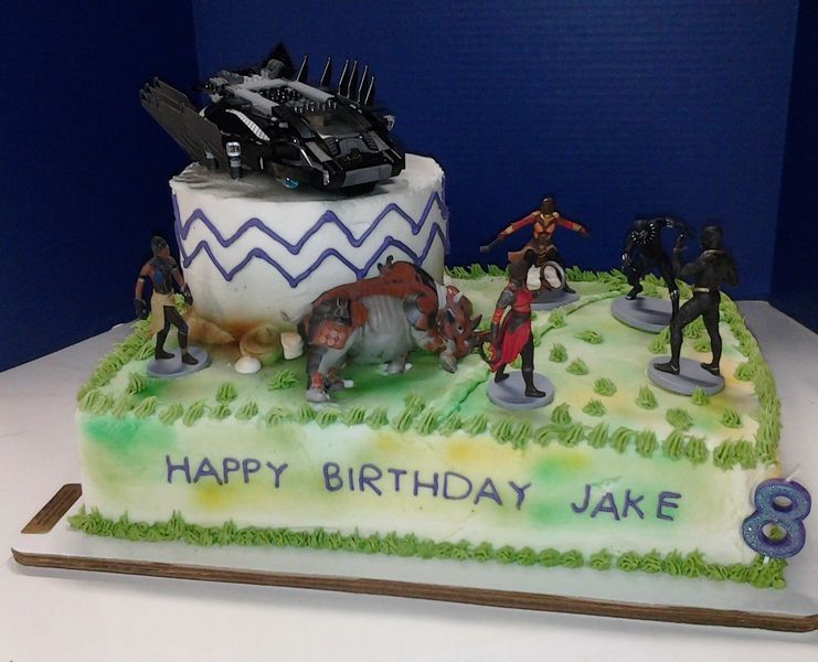 Birthday cake with Black Panther figures and a vehicle on a green grassy field, with 