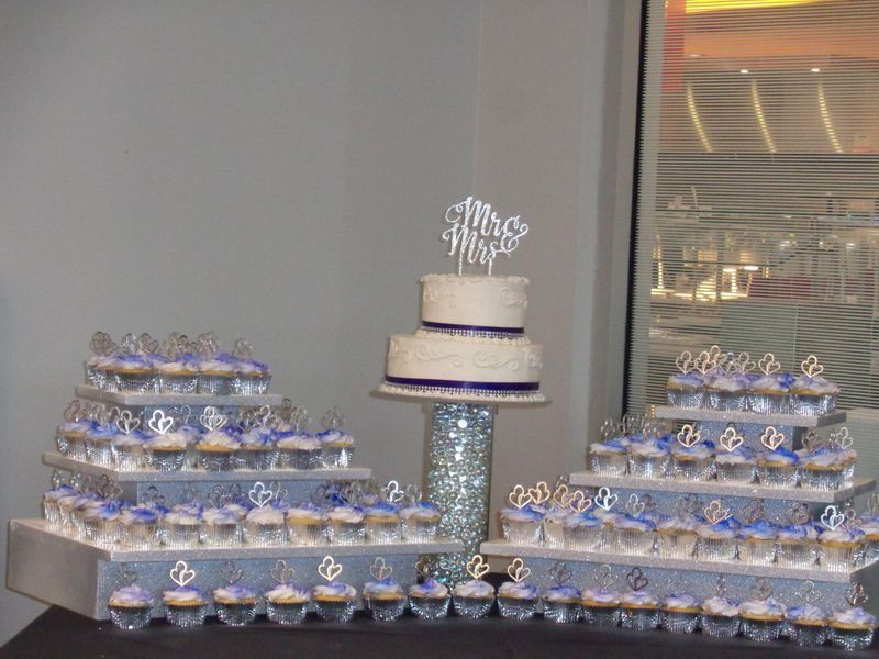 Wedding cupcakes and cake display with silver and purple accents.