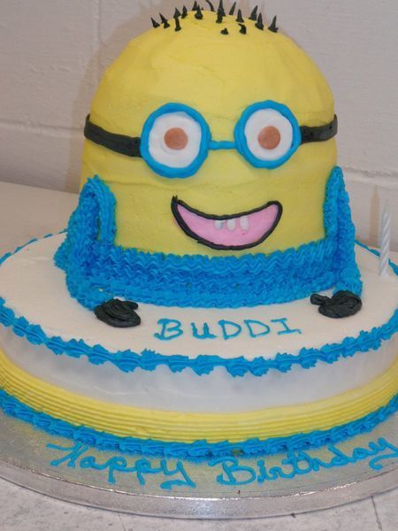 Minion birthday cake: yellow and blue frosting, glasses, smiling, 