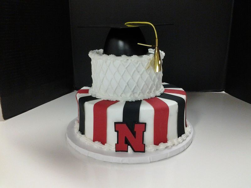 Graduation cake with black mortarboard, red/black/white stripes, and a red 