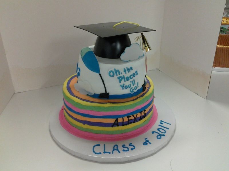 Two-tiered graduation cake with colorful stripes, mortarboard, and 