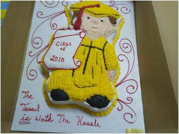 Graduation cake shaped like a graduate in yellow gown, cap, and holding a scroll; text 