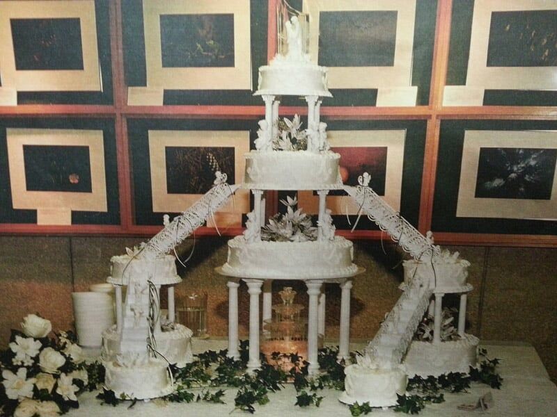 Elaborate white tiered wedding cake with connecting bridges and columns.