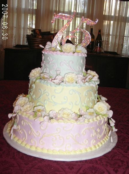 Three-tiered pastel cake with floral decorations and a 