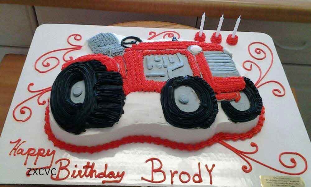 Birthday cake shaped like a red tractor with black tires, 