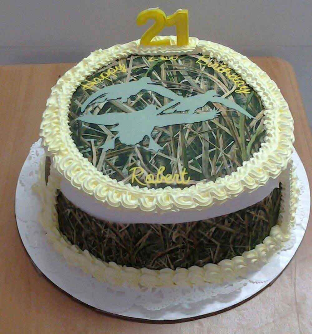 Cake decorated with camouflage and ducks, topped with a 