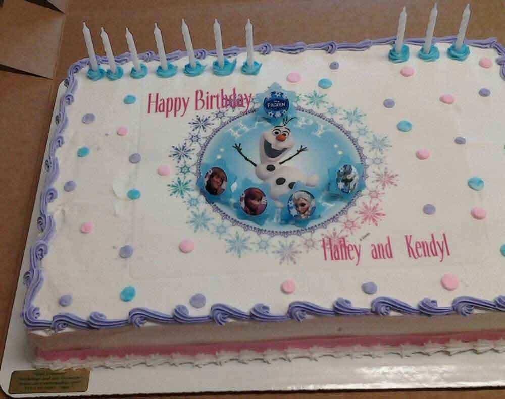 Rectangular cake decorated with an Olaf-themed image, candles, and “Happy Birthday.”
