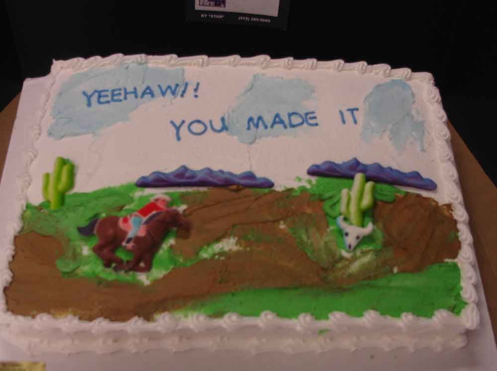 Cake decorated with a cowboy on a horse, cacti, and text 