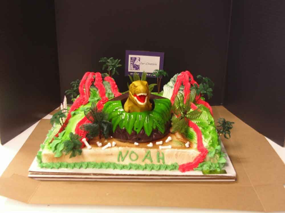 Dinosaur cake with volcano and T-Rex, green frosting, name 