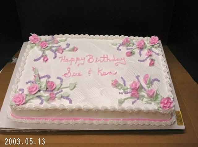 Rectangular birthday cake with pink frosting roses and the words 