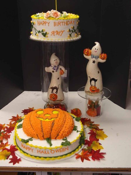 Halloween and birthday-themed cake display with pumpkin, ghosts, and fall leaves.
