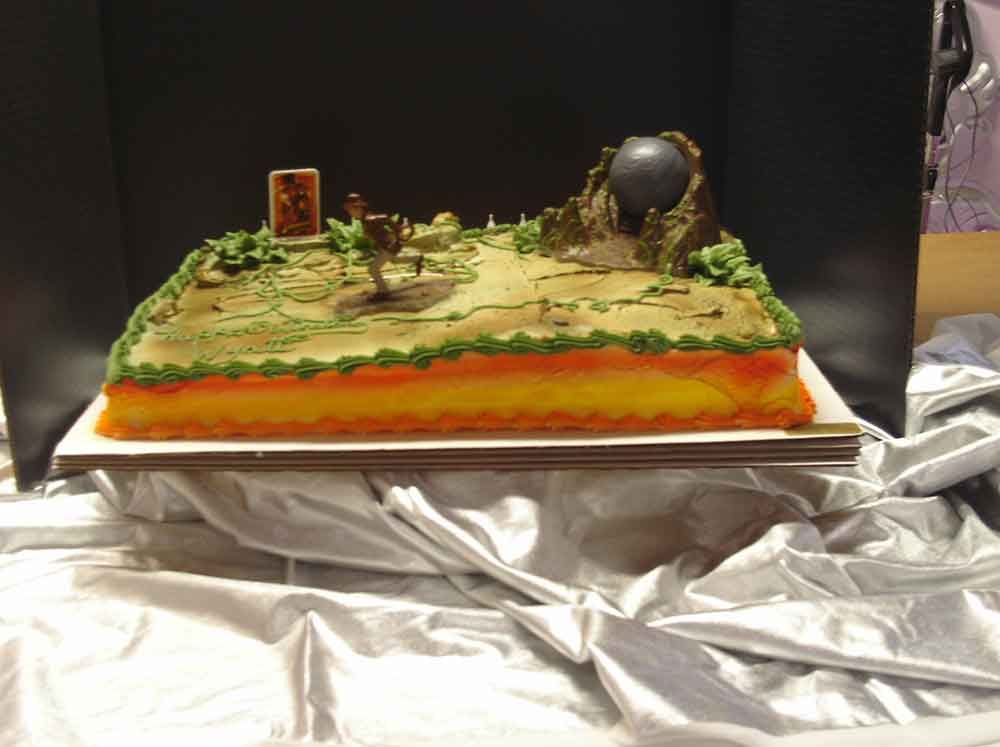 Cake decorated as a desert landscape with a large rock formation and a sphere.
