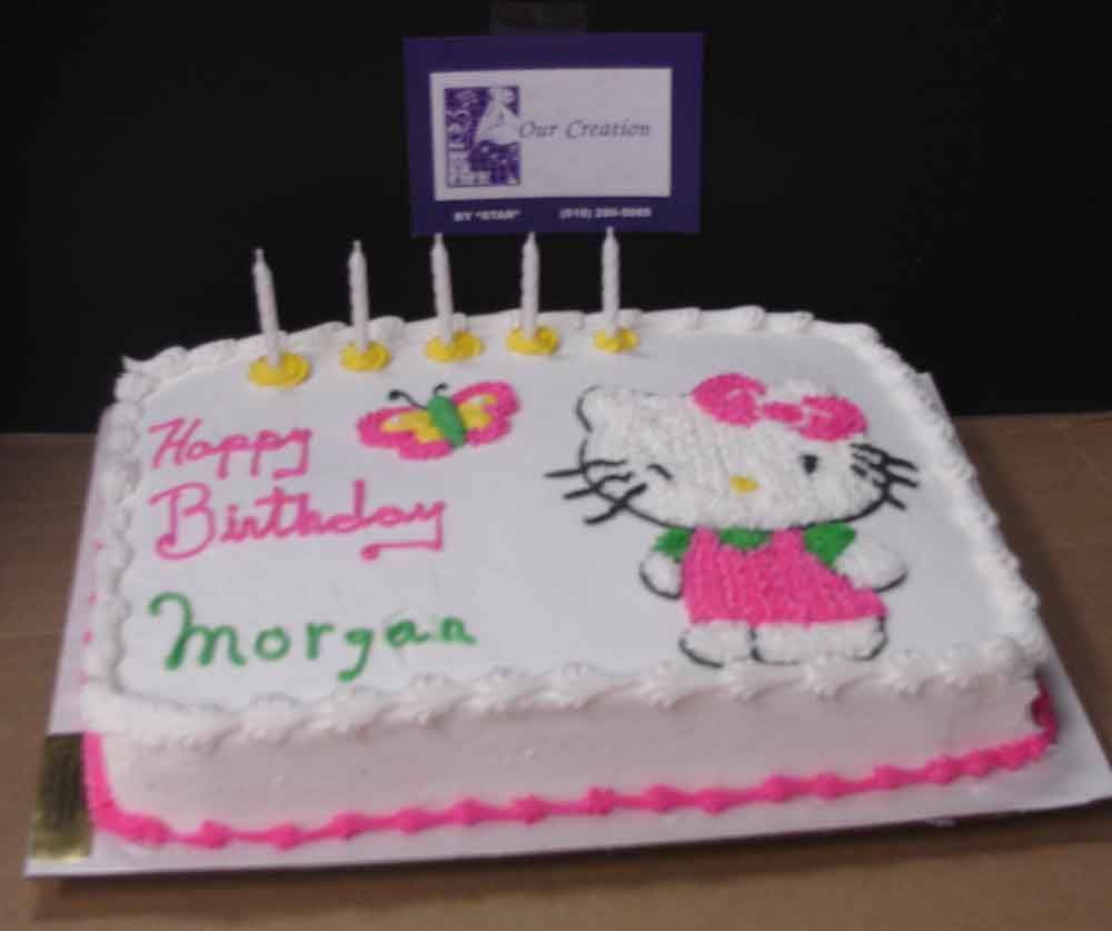 Birthday cake decorated with Hello Kitty and a butterfly; candles and text that reads 