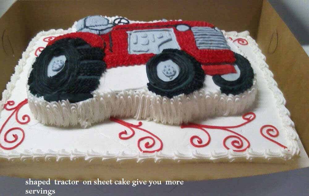 Red tractor cake on a white sheet cake with red swirls, inside a box.