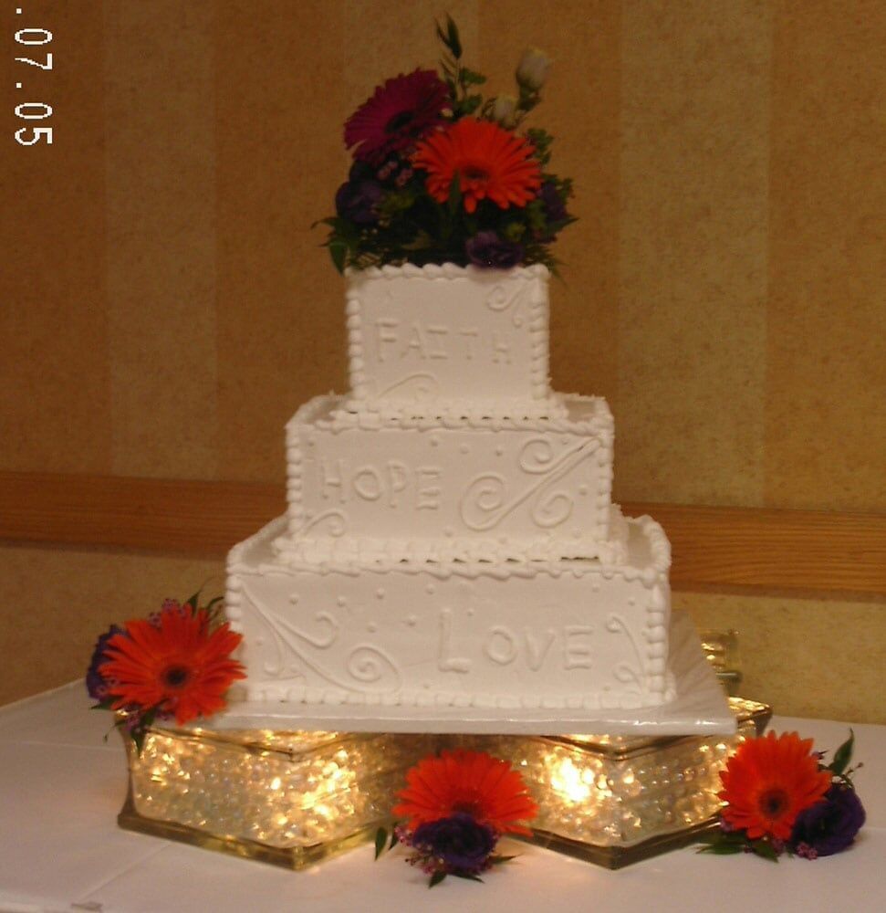 Three-tiered white wedding cake with 