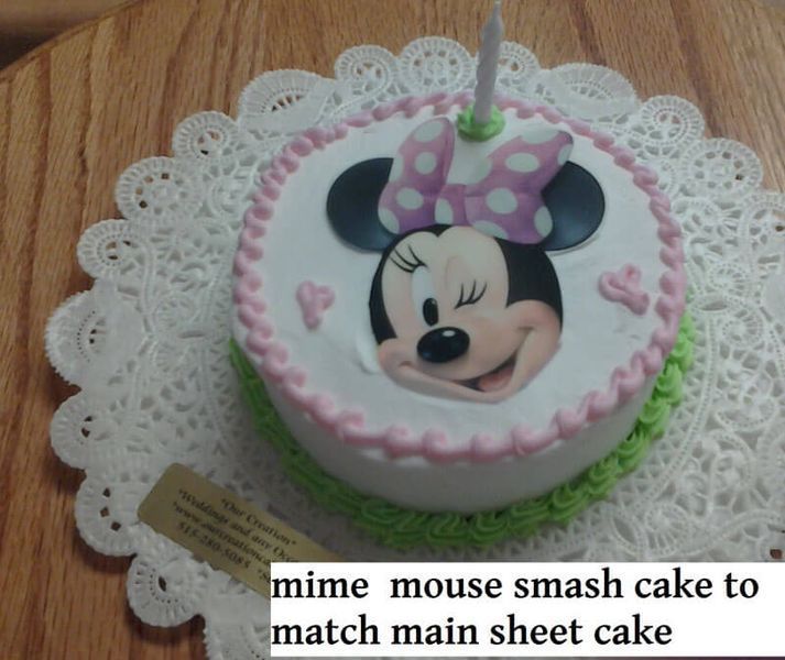 Minnie Mouse smash cake with a candle on a doily.