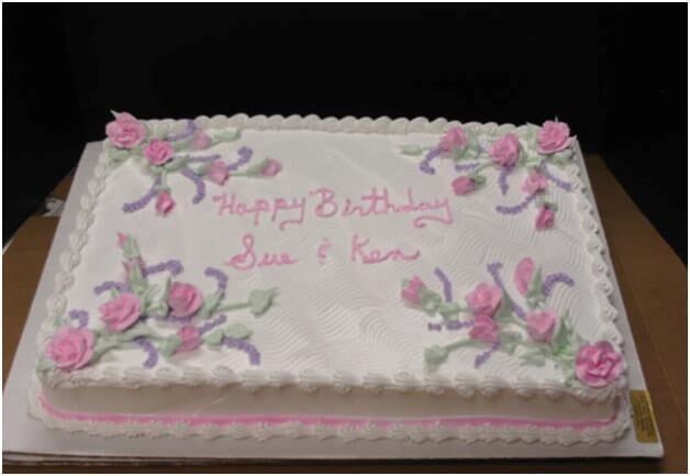 Birthday cake with white frosting, pink roses, and 