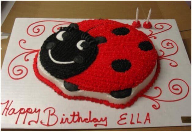 Ladybug birthday cake with red icing, black spots, and 
