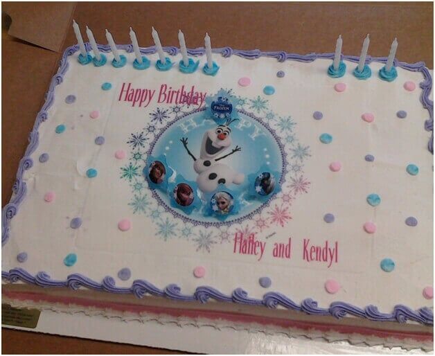 Birthday cake decorated with an Olaf-themed image, candles, and names.