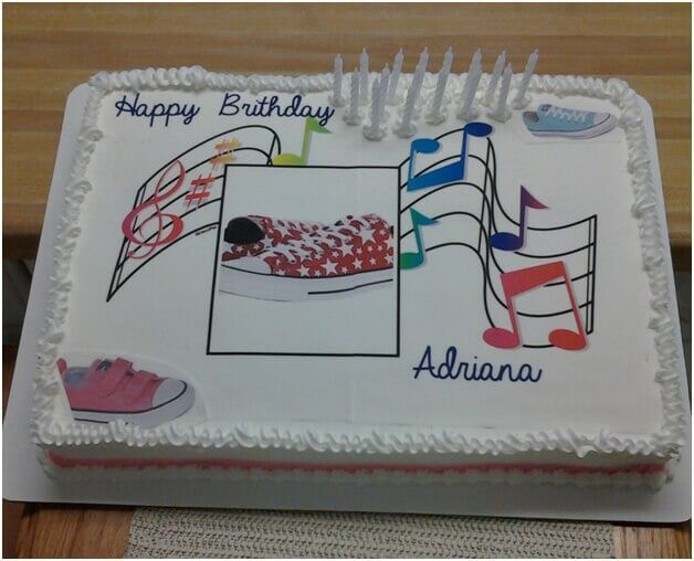 Birthday cake with music notes and shoe decorations, photo in the center, candles.