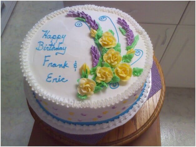 Birthday cake decorated with yellow roses, lavender, and 