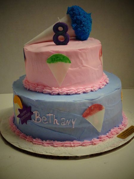 Two-tiered birthday cake, blue and pink frosting, snow cone design, 