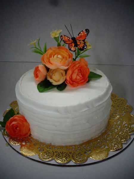 Cake decorated with orange flowers and a butterfly.