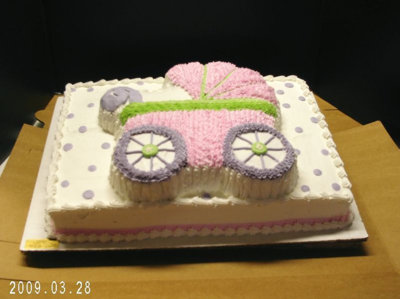 Baby carriage cake with pink, purple, green frosting. Square cake with polka dots.