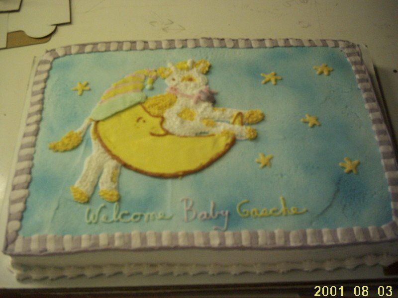Cake decorated with a giraffe on a crescent moon, blue background, 