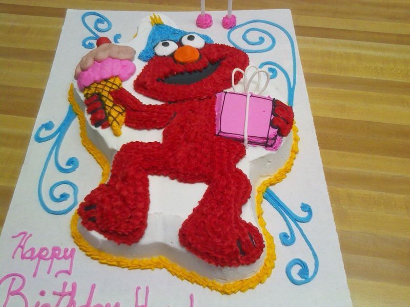 Elmo cake, holding ice cream and a gift, wearing a party hat. 