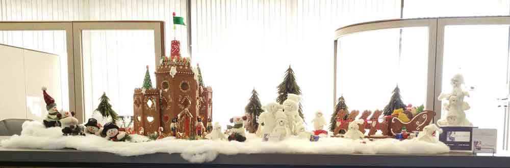 Christmas gingerbread village display with castle, trees, snowmen, sleigh, and gnomes.
