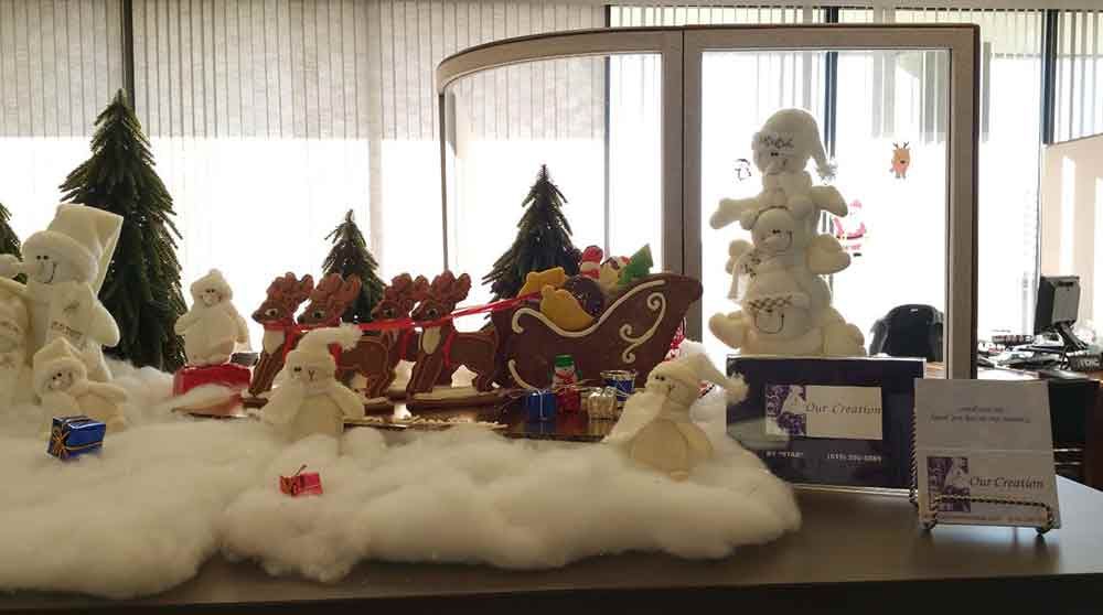 Christmas display featuring snowman figures, gingerbread reindeer and sleigh, and Christmas trees.