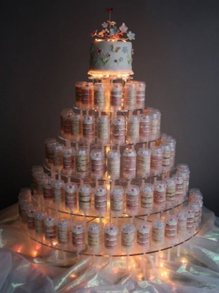 Tiered dessert cake with clear cupcake packaging, lit up, with small top layer.