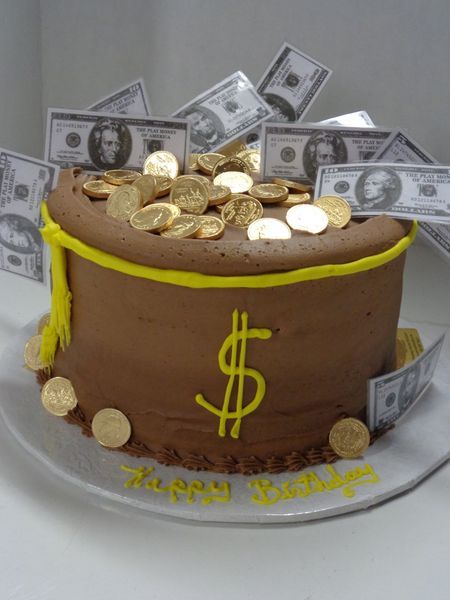 Chocolate cake decorated as a money bag, with dollar bills and gold coins.