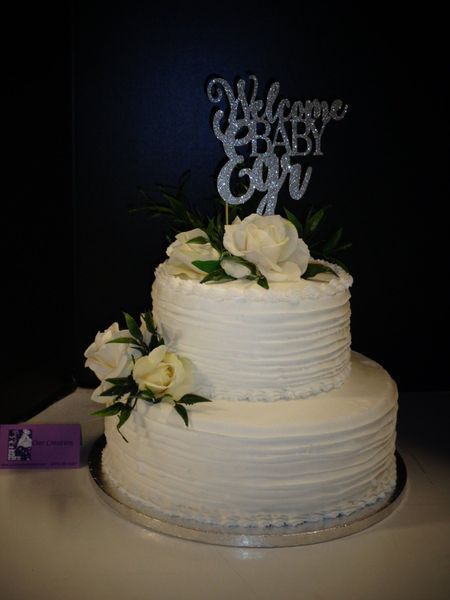 Two-tiered white cake with roses and a 