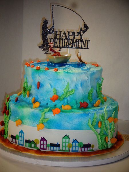 Two-tier retirement cake with blue ocean design, fishing theme, and 
