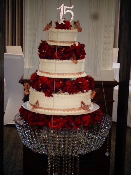 Five-tiered red and cream cake with butterflies and a 