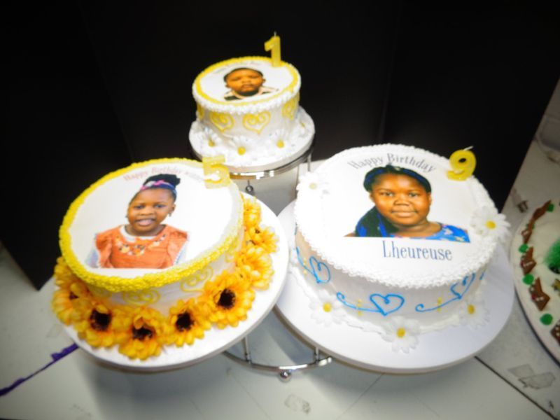 Three birthday cakes with photo prints and candles. Yellow and blue frosting.