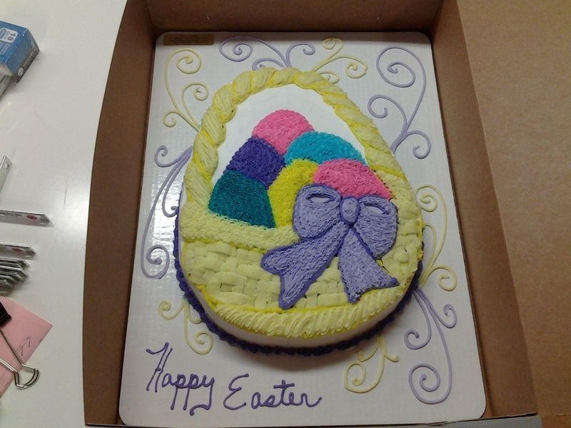 Easter basket cake with colorful eggs and purple bow. 