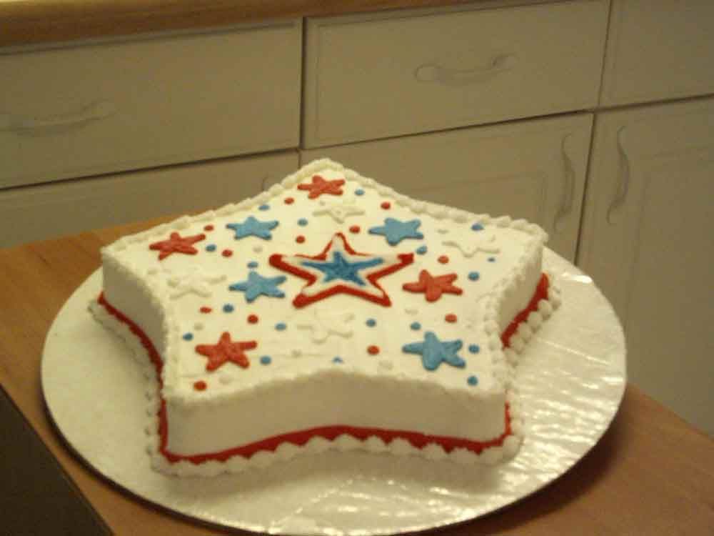 Star-shaped cake decorated with red, white, and blue stars and dots.