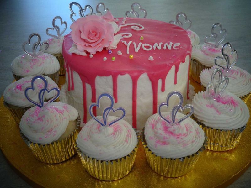 Cake with pink frosting and cupcakes, decorated for 
