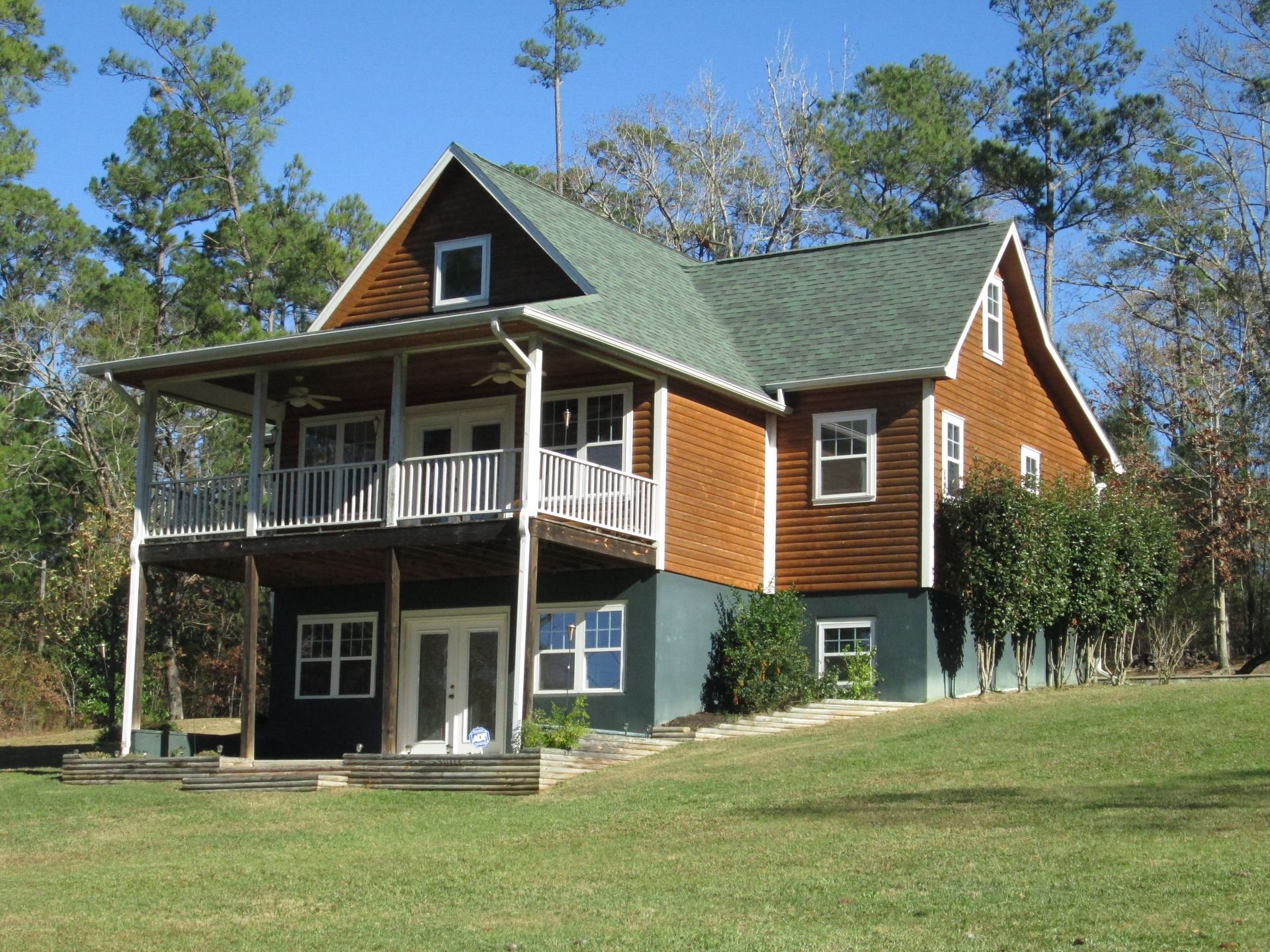 a large house sits on top of a grassy hill
