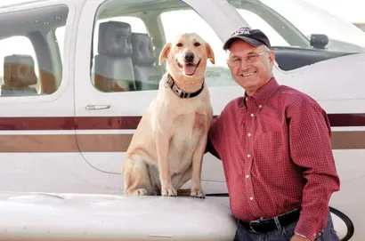 Ron Johnston and his dog standing outside against truck