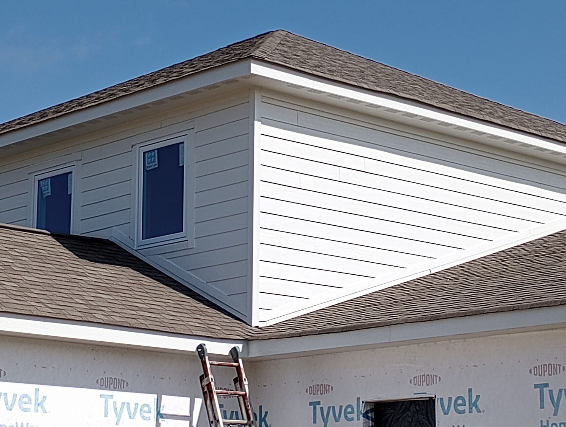 A ladder is sitting on the side of a house under construction