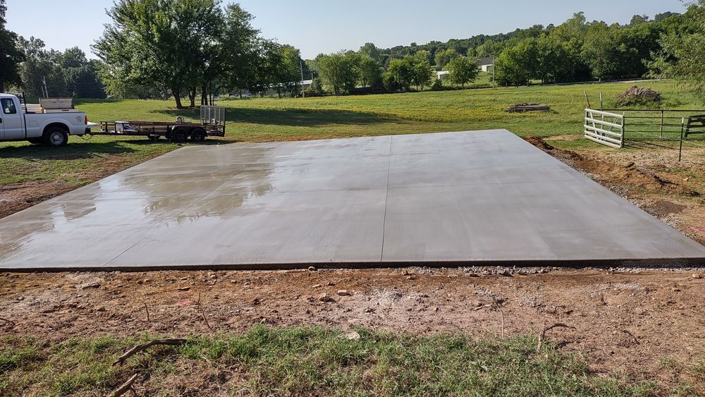 A white truck is parked next to a large concrete slab.