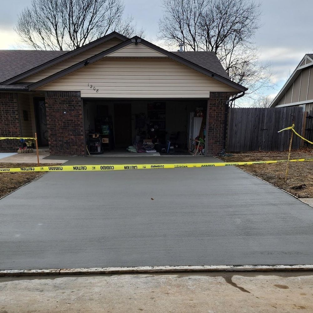 A brick house with a concrete driveway in front of it