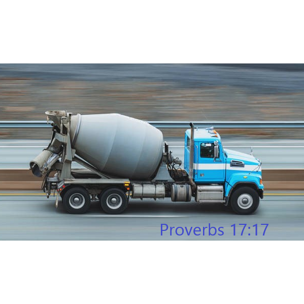 A blue concrete mixer truck is driving down a highway.