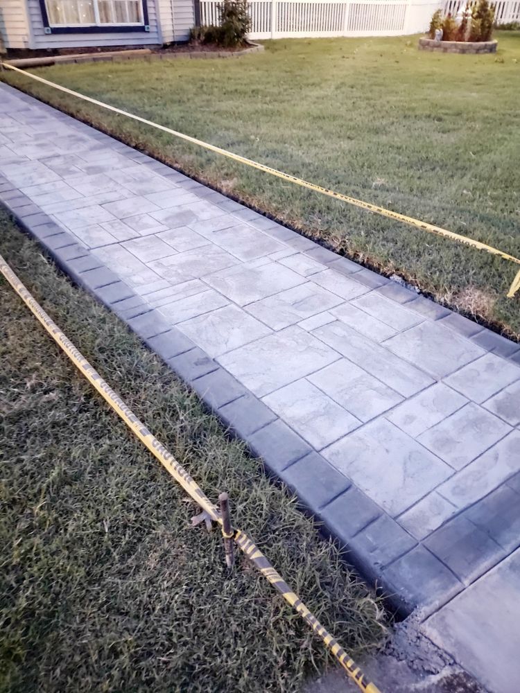 A concrete walkway is being built in front of a house.